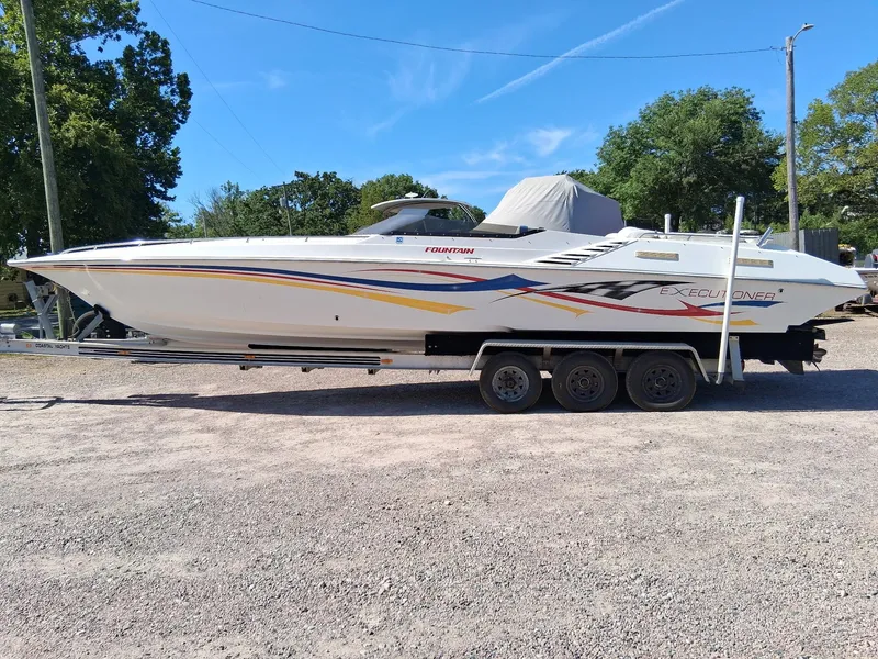 Slide: The Image of 2003 Fountain 35 Executioner speedboat on trailer, parked outdoors, clear sky background. - 15