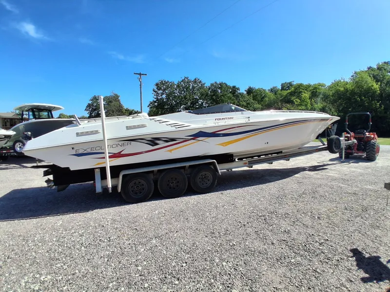Slide: The Image of 2003 Fountain 35 Executioner speedboat on trailer, parked outdoors under clear blue sky. - 16