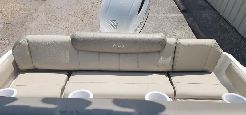 Slide: The Image of 2024 Key West 219fs boat with beige cushioned seating and cup holders. - 16