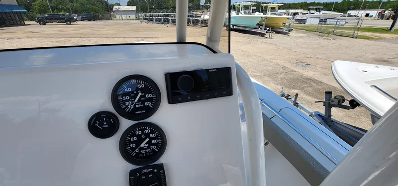 Slide: The Image of 2024 Key West 219fs boat dashboard with gauges and controls in a marina setting. - 33