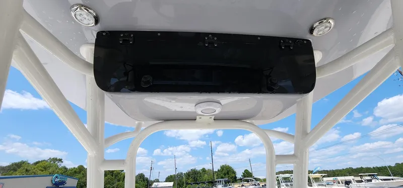 Slide: The Image of 2024 Key West 219fs boat T-top with electronics box, under a clear blue sky. - 34