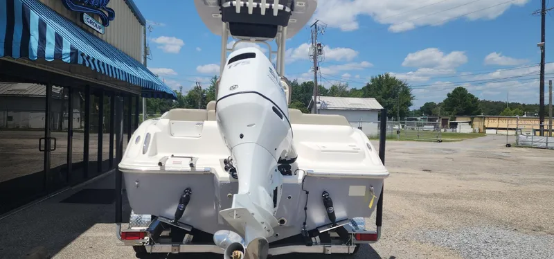 Slide: The Image of 2024 Key West 219fs boat with outboard motor, parked outside dealership under blue sky. - 7