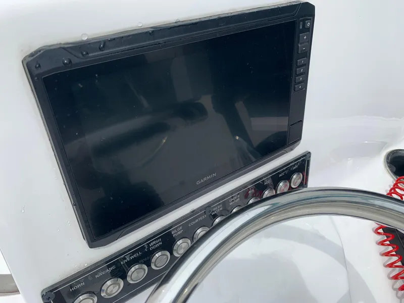 Slide: The Image of 2024 Tidewater 1910BM boat dashboard with Garmin display and control panel. - 23