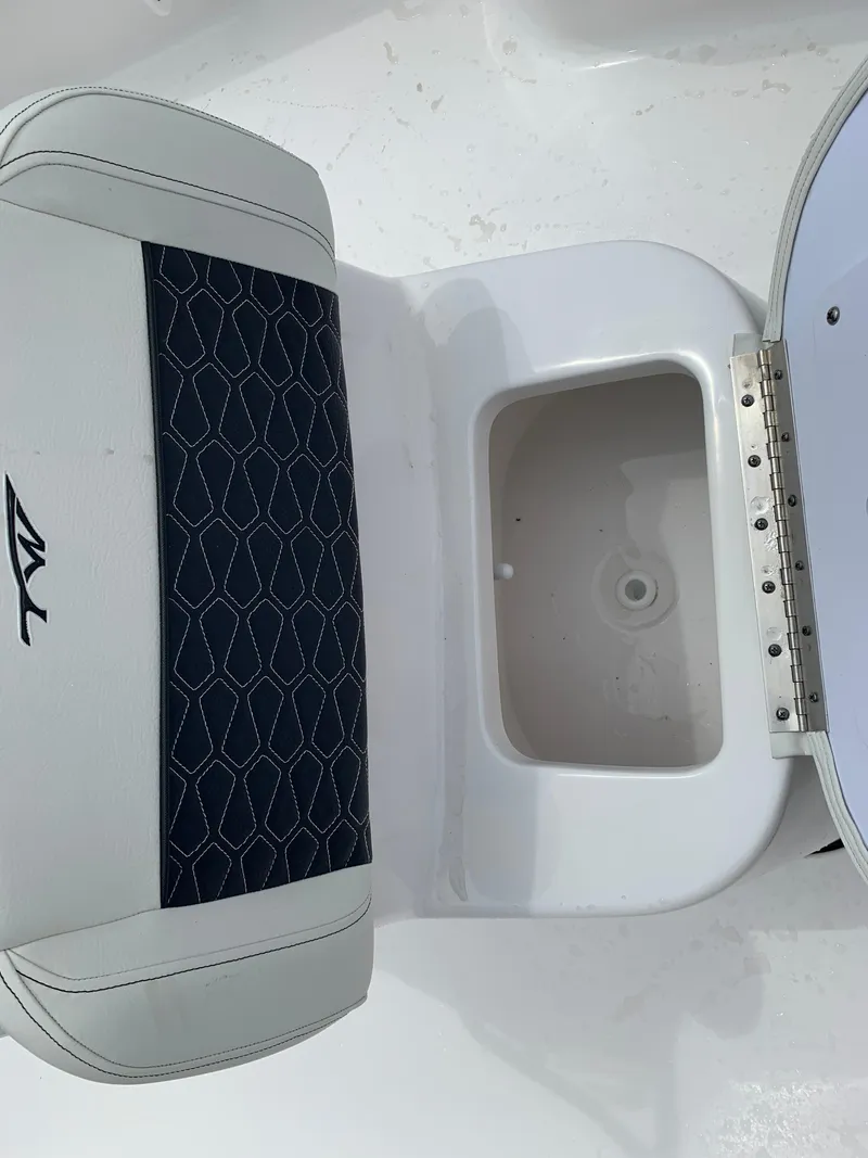 Slide: The Image of 2024 Tidewater 1910BM boat seat with storage compartment, white and black design. - 27