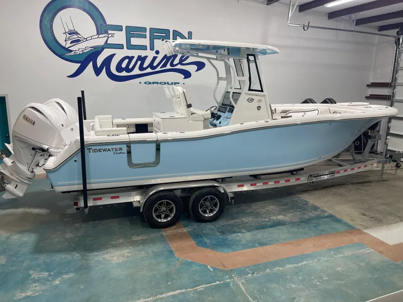 Slide: The Image of 2024 Tidewater 272LXF boat on trailer in showroom, featuring Yamaha engine. - 1