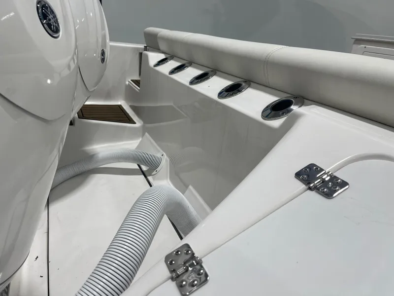 Slide: The Image of 2024 Tidewater 272LXF boat interior with rod holders and white seating. - 13