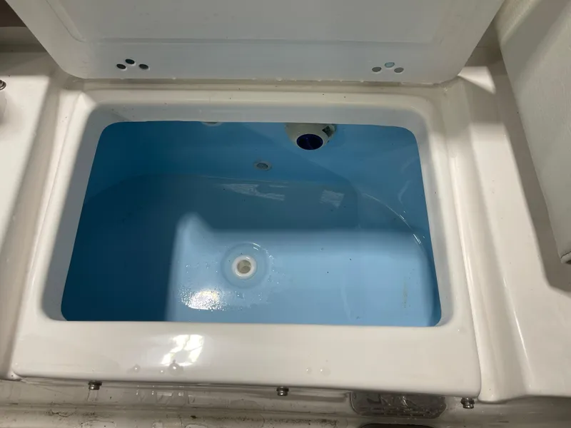 Slide: The Image of 2024 Tidewater 272LXF boat livewell with open lid, showcasing interior. - 18