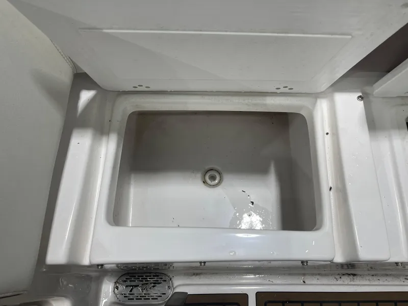 Slide: The Image of 2024 Tidewater 272LXF boat sink, white and clean, with drain. - 19