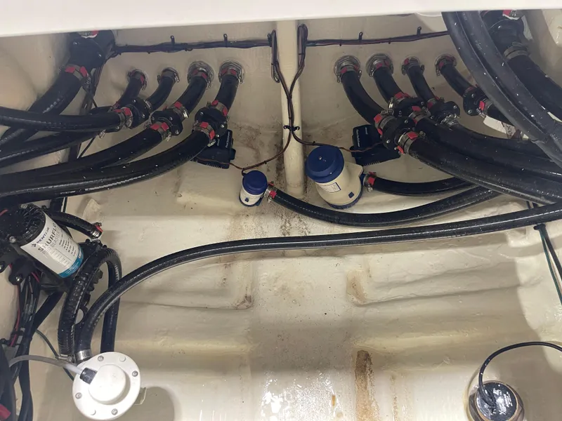 Slide: The Image of 2024 Tidewater 272LXF boat bilge area with hoses and pumps. - 21