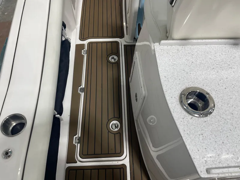 Slide: The Image of 2024 Tidewater 272LXF boat interior with teak flooring and white countertops. - 24