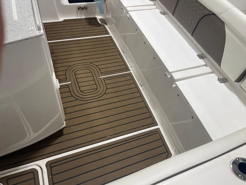 Slide: The Image of 2024 Tidewater 272LXF boat interior with teak-style flooring and cushioned seating. - 28