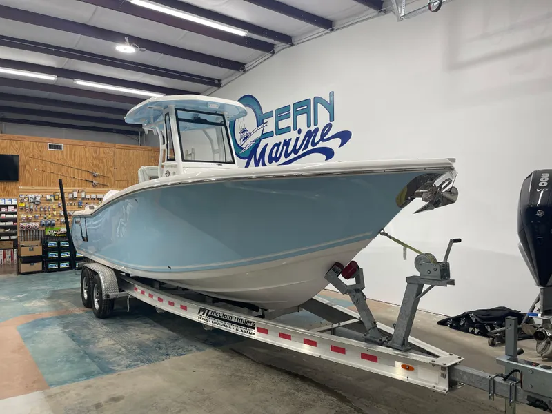 Slide: The Image of 2024 Tidewater 272LXF boat on trailer in showroom, Ocean Marine logo in background. - 3