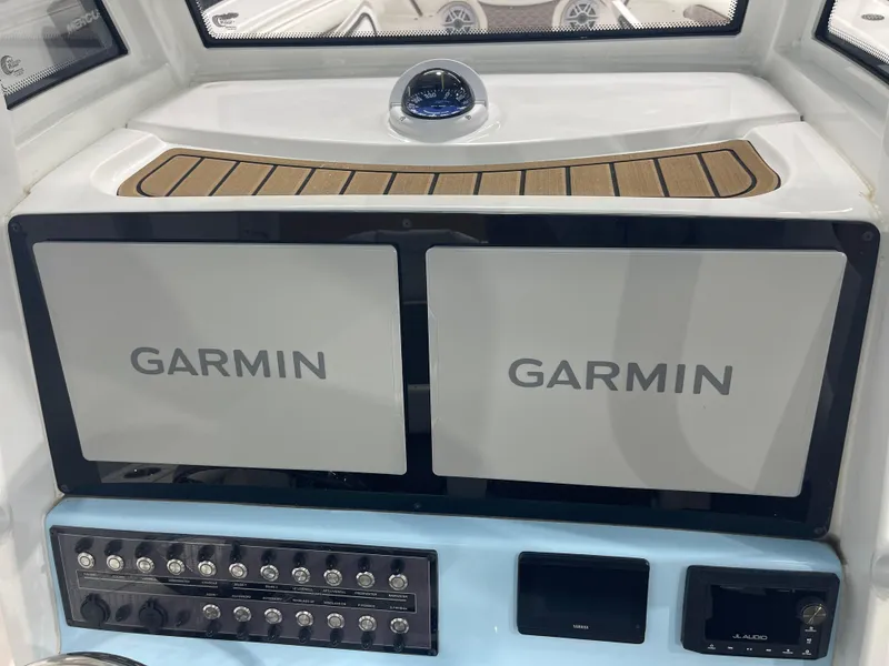 Slide: The Image of 2024 Tidewater 272LXF boat dashboard with dual Garmin displays and control panel. - 34