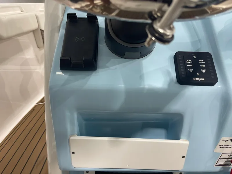 Slide: The Image of 2024 Tidewater 272LXF boat console with controls and phone holder. - 40