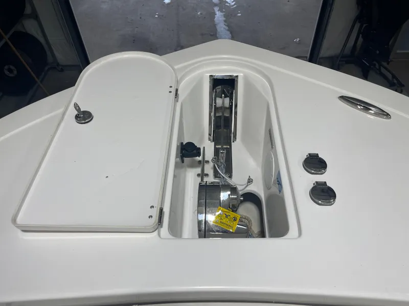 Slide: The Image of 2024 Tidewater 272LXF boat anchor compartment with open hatch and visible winch. - 45