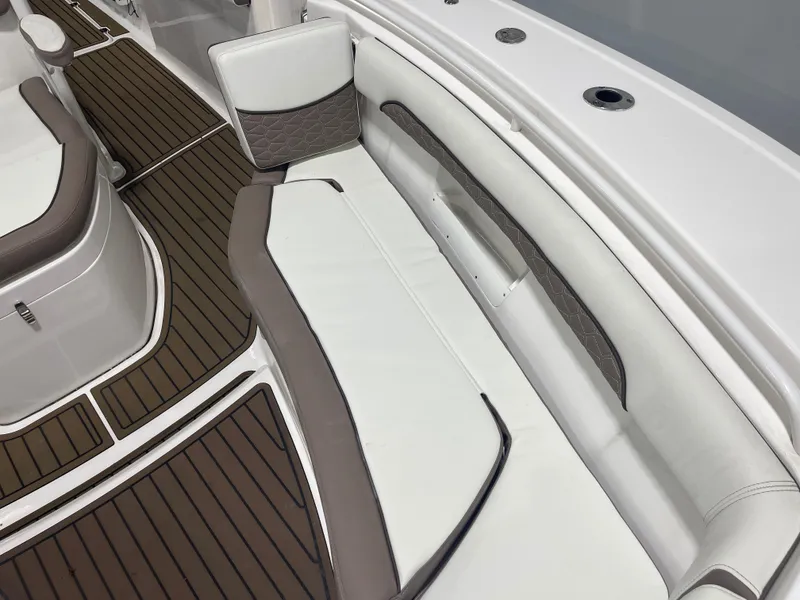 Slide: The Image of 2024 Tidewater 272LXF boat interior with cushioned seating and teak-style flooring. - 49