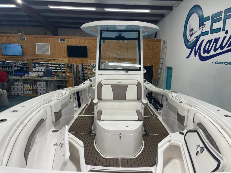 Slide: The Image of 2024 Tidewater 272LXF boat interior in showroom, featuring seating and storage compartments. - 6