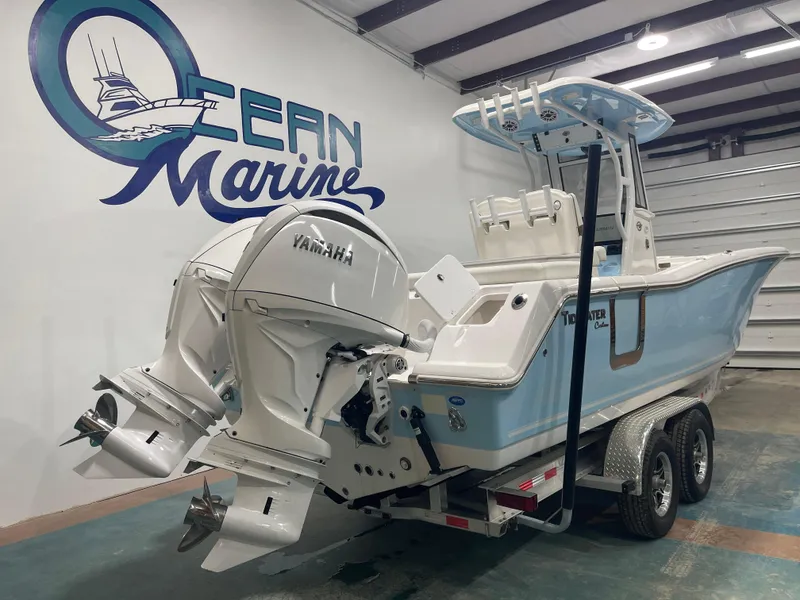 Slide: The Image of 2024 Tidewater 272LXF boat with dual Yamaha engines in a showroom. - 7