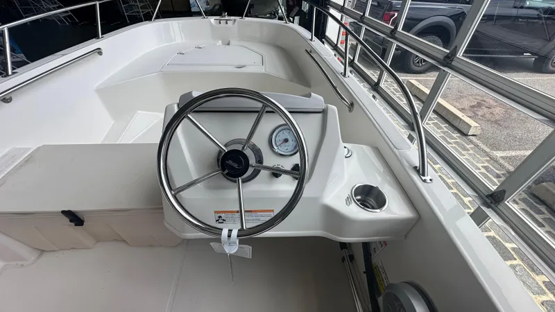 Slide: The Image of 2025 Boston Whaler 160 Super Sport boat interior with steering wheel and dashboard. - 10