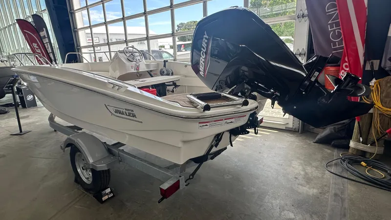 Slide: The Image of 2025 Boston Whaler 160 Super Sport boat with Mercury engine in showroom. - 2