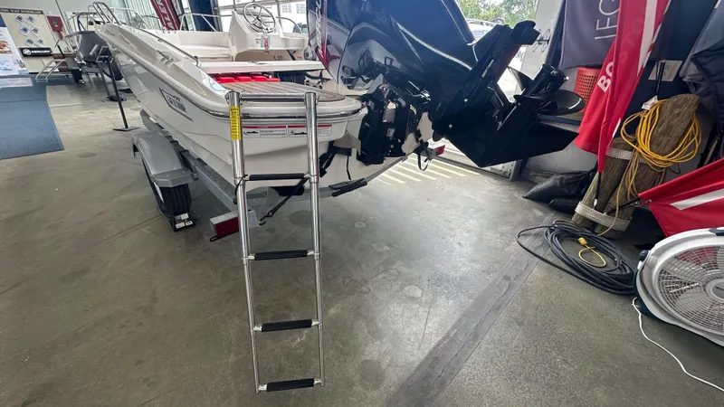 Slide: The Image of 2025 Boston Whaler 160 Super Sport boat on trailer with ladder in showroom. - 5
