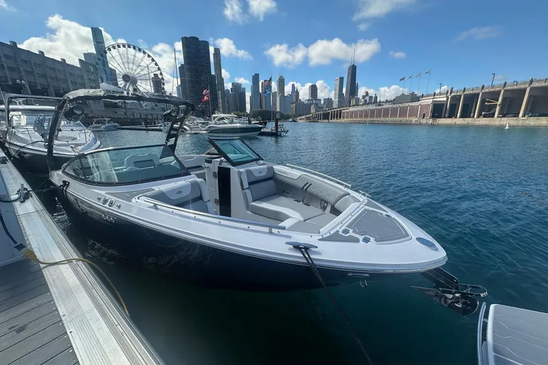Slide: The Image of 2025 Regal LS6 Surf boat docked on a sunny day, showcasing sleek design and spacious seating. - 2