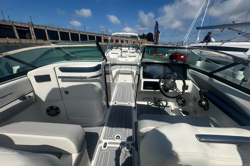 Slide: The Image of 2025 Regal LS6 Surf boat with sleek interior, docked under a clear blue sky. - 4