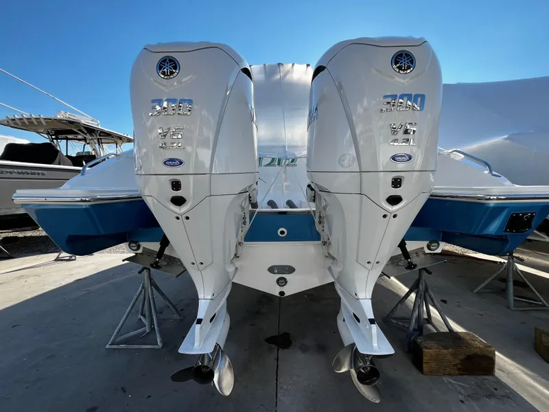 Slide: The Image of 2024 Pursuit OS 325 boat with dual Yamaha 300 engines, docked under clear blue sky. - 1
