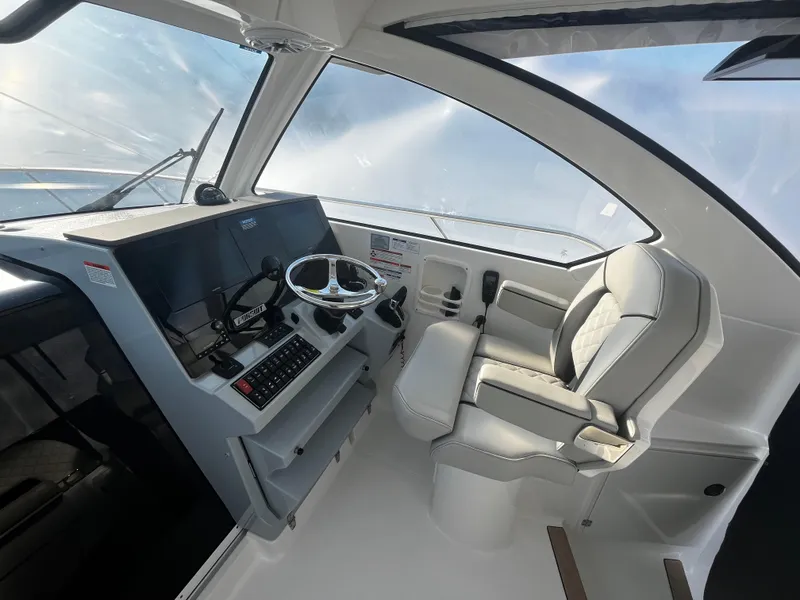 Slide: The Image of 2024 Pursuit OS 325 boat cockpit with modern steering and comfortable seating. - 12