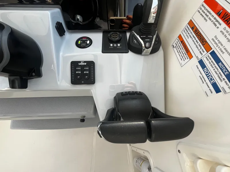 Slide: The Image of 2024 Pursuit OS 325 boat control panel with throttle and warning labels. - 14