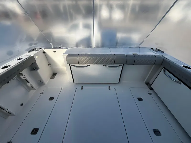 Slide: The Image of 2024 Pursuit OS 325 boat interior with cushioned seating and storage compartments. - 2