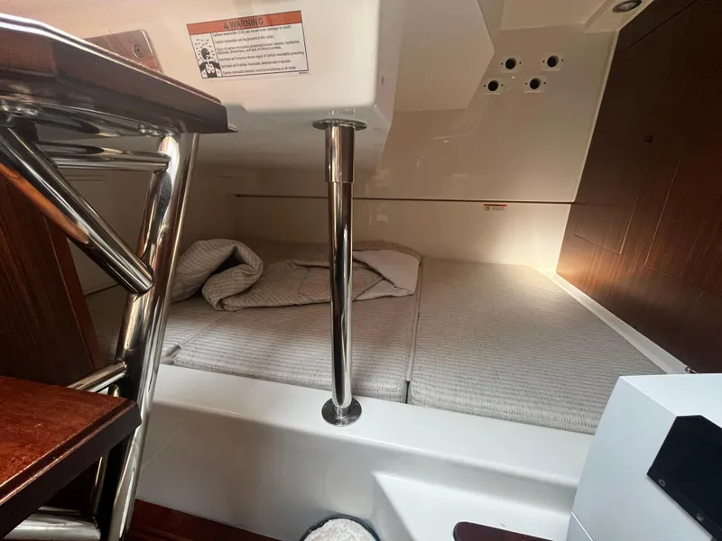 Slide: The Image of 2024 Pursuit OS 325 cabin interior with bed and metal support pole. - 23