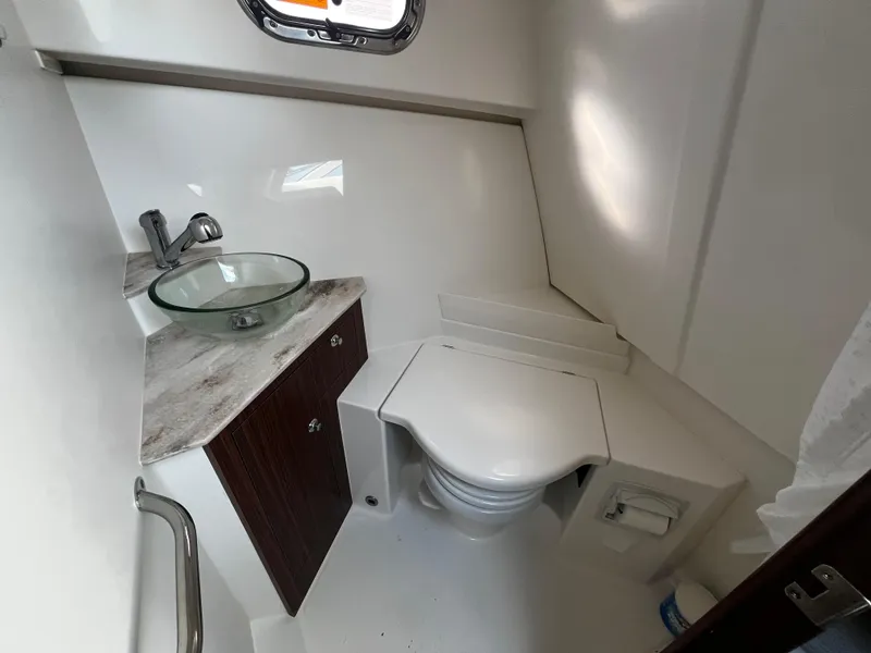 Slide: The Image of 2024 Pursuit OS 325 boat bathroom with modern sink and toilet. - 25
