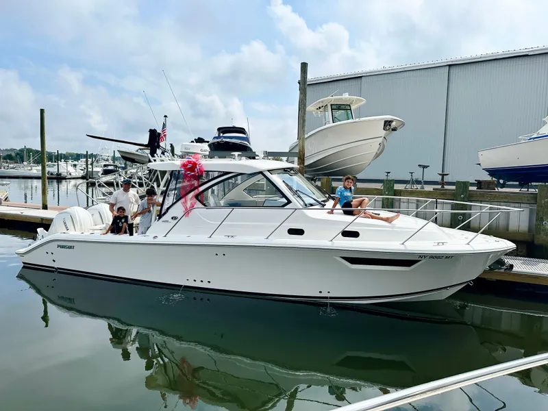 Slide: The Image of 2024 Pursuit OS 325 boat docked at marina with people onboard. - 28