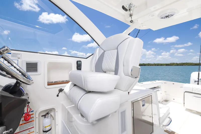 Slide: The Image of 2024 Pursuit OS 325 boat interior with luxurious white seating and ocean view. - 33