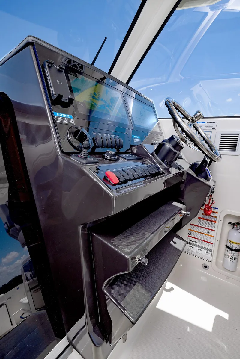Slide: The Image of 2024 Pursuit OS 325 boat helm with modern controls and steering wheel. - 35