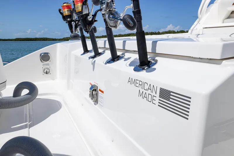 Slide: The Image of 2024 Pursuit OS 325 boat with fishing rods, "American Made" label, and American flag. - 43