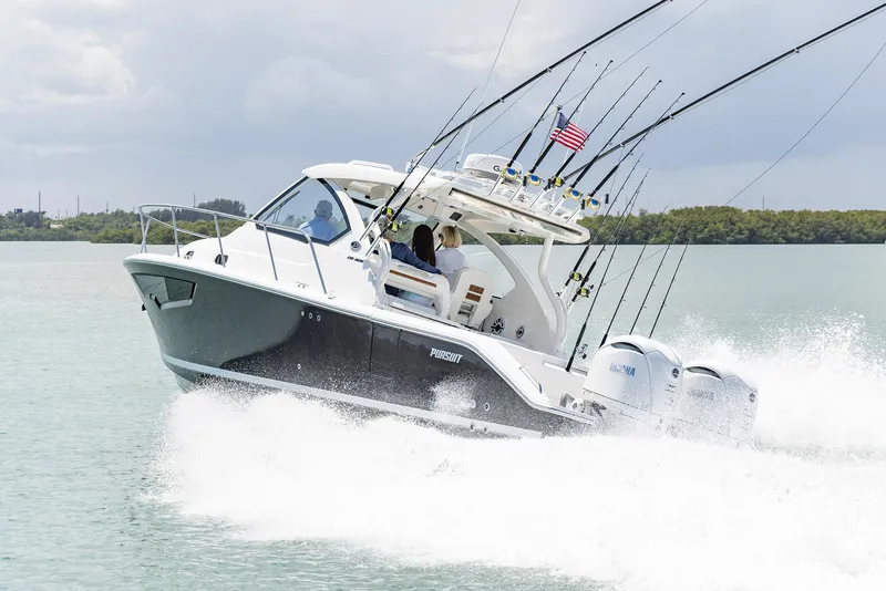 Slide: The Image of 2024 Pursuit OS 325 boat cruising on water with fishing rods and American flag. - 46