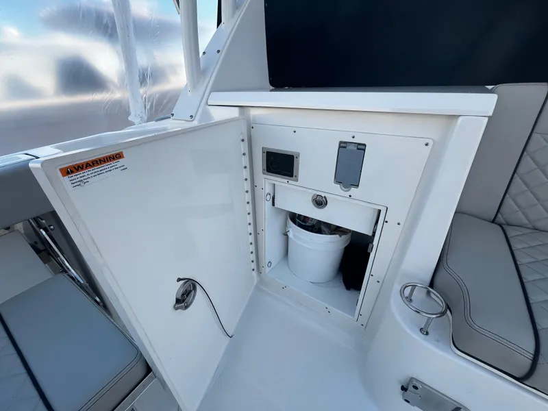 Slide: The Image of 2024 Pursuit OS 325 boat interior with storage compartment and seating area. - 7