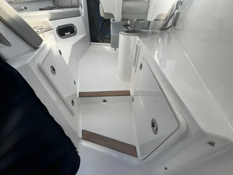 Slide: The Image of 2024 Pursuit OS 325 boat interior with sleek white design and storage compartments. - 9