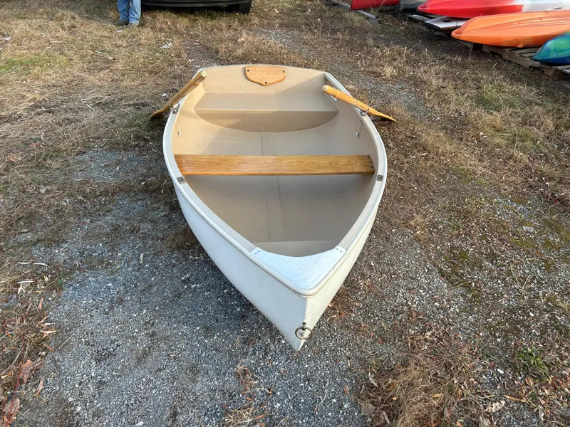 Slide: The Image of Puffin 860 boat, 2022 model, on gravel ground with wooden seats and oars. - 6