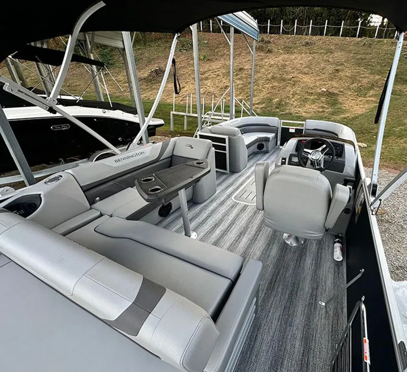 Slide: The Image of 2025 Bennington SX 22 Swingback pontoon boat with spacious seating at a marina. - 11