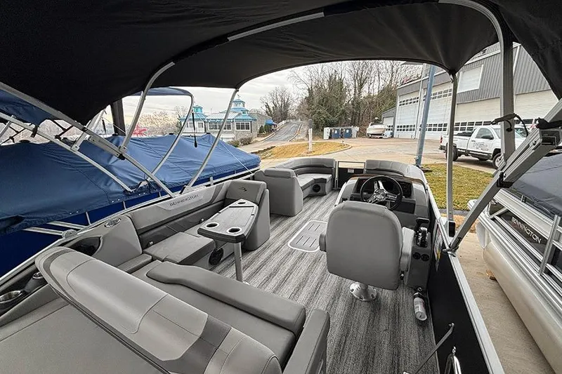 Slide: The Image of 2025 Bennington SX 22 Swingback interior storage compartment with open hatch on carpeted floor. - 13