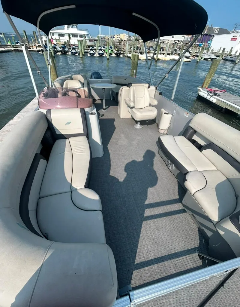 Slide: The Image of 2022 Starcraft EX 20 R pontoon boat with spacious seating and canopy at a marina. - 2