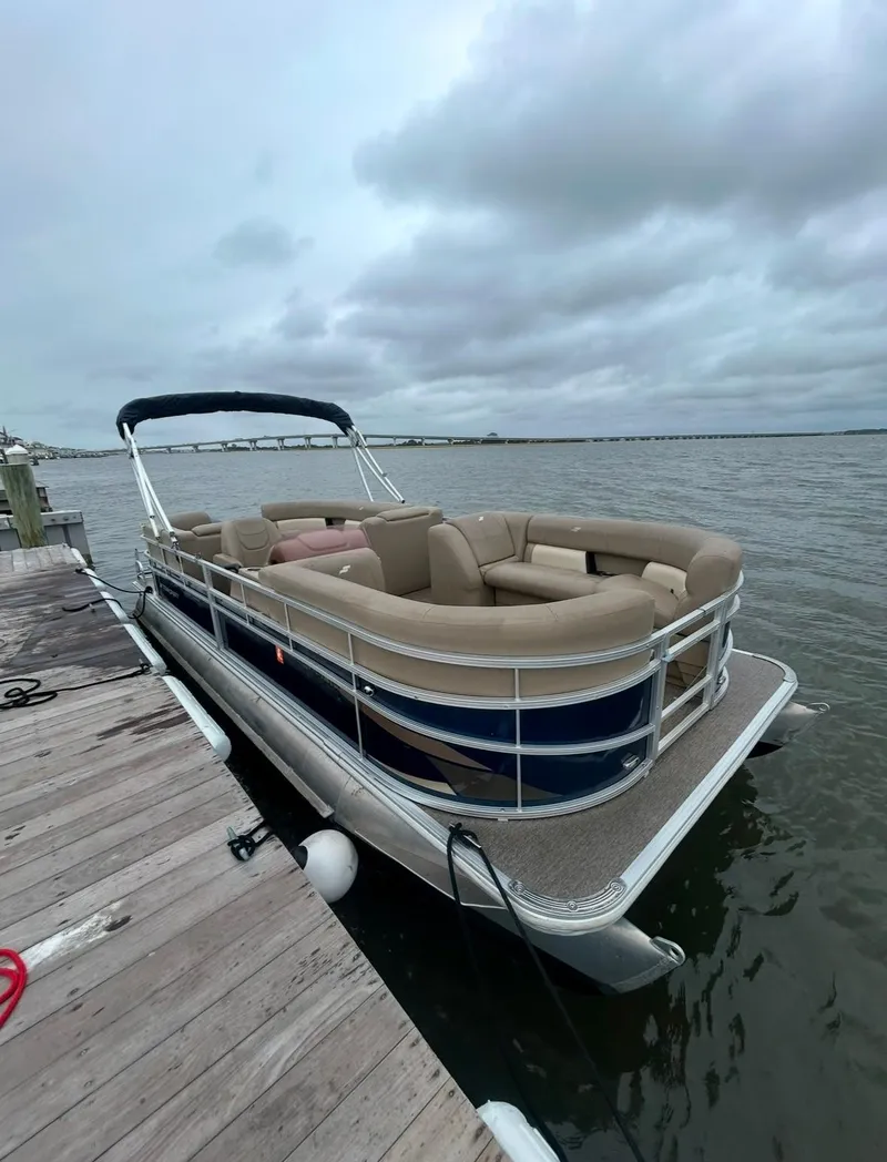 Slide: The Image of 2022 Starcraft LX 22 R pontoon boat docked on a cloudy day. - 3
