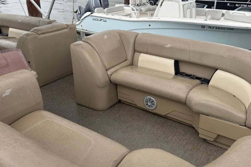 Slide: The Image of 2022 Starcraft LX 22 R boat interior with beige seating and cup holders. - 4