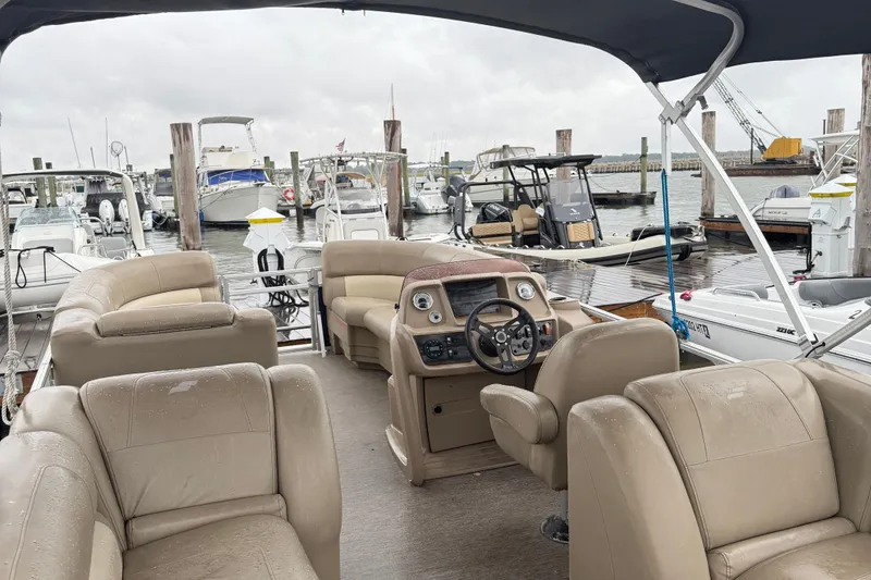 Slide: The Image of 2022 Starcraft LX 22 R pontoon boat interior at marina dock. - 7