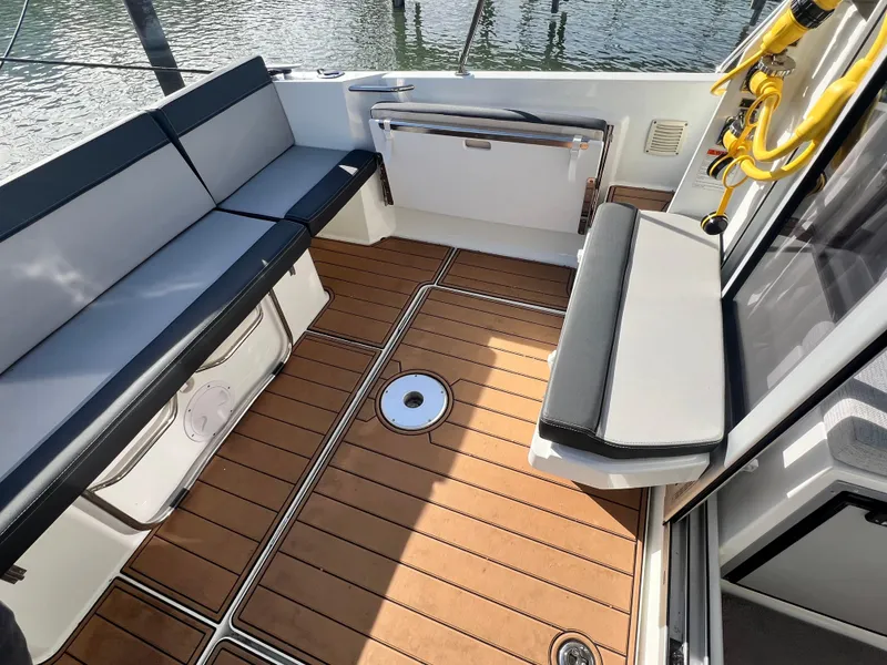 Slide: The Image of 2022 Jeanneau NC 795 S2 boat interior with cushioned seating and wooden flooring. - 18