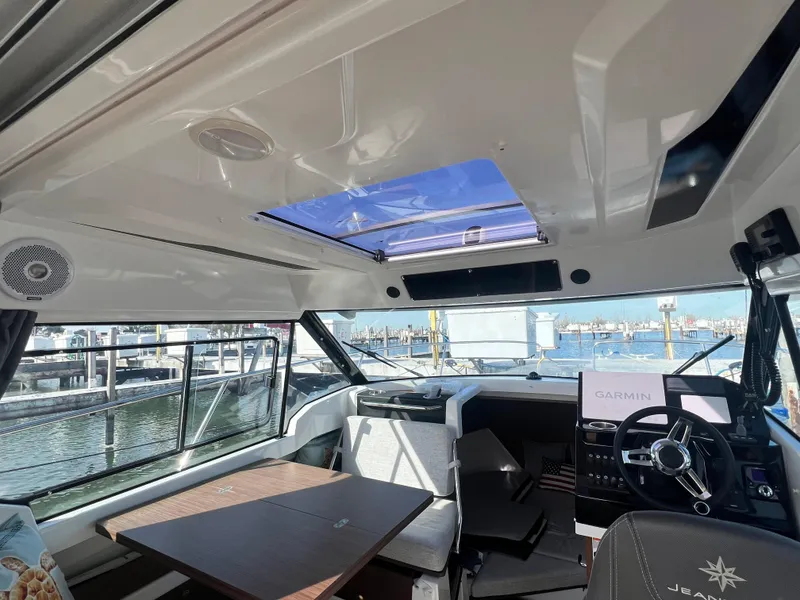 Slide: The Image of Interior of 2022 Jeanneau NC 795 S2 boat with steering wheel and seating area. - 22
