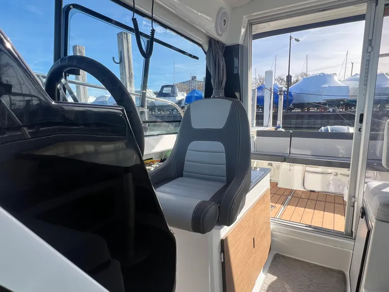 Slide: The Image of Interior view of 2022 Jeanneau NC 795 S2 boat, featuring helm and seating area. - 27